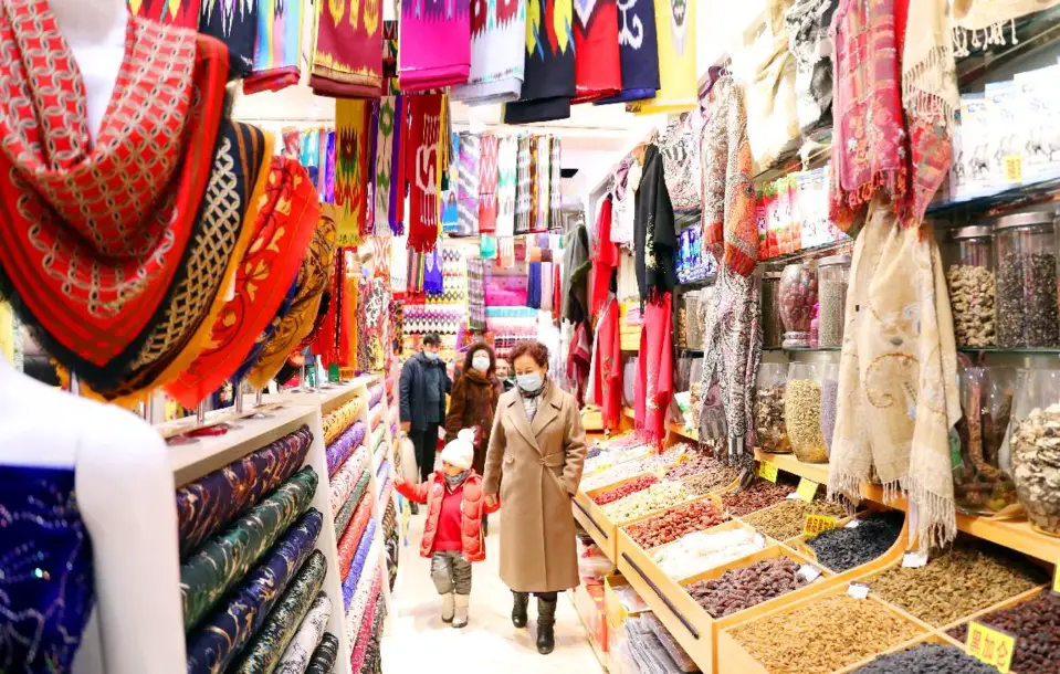 People shop at the Xinjiang International Grand Bazaar, northwest China’s Xinjiang Uygur autonomous region, Nov. 26, 2021. (Photo by Zhang Xiuke/People’s Daily Online)