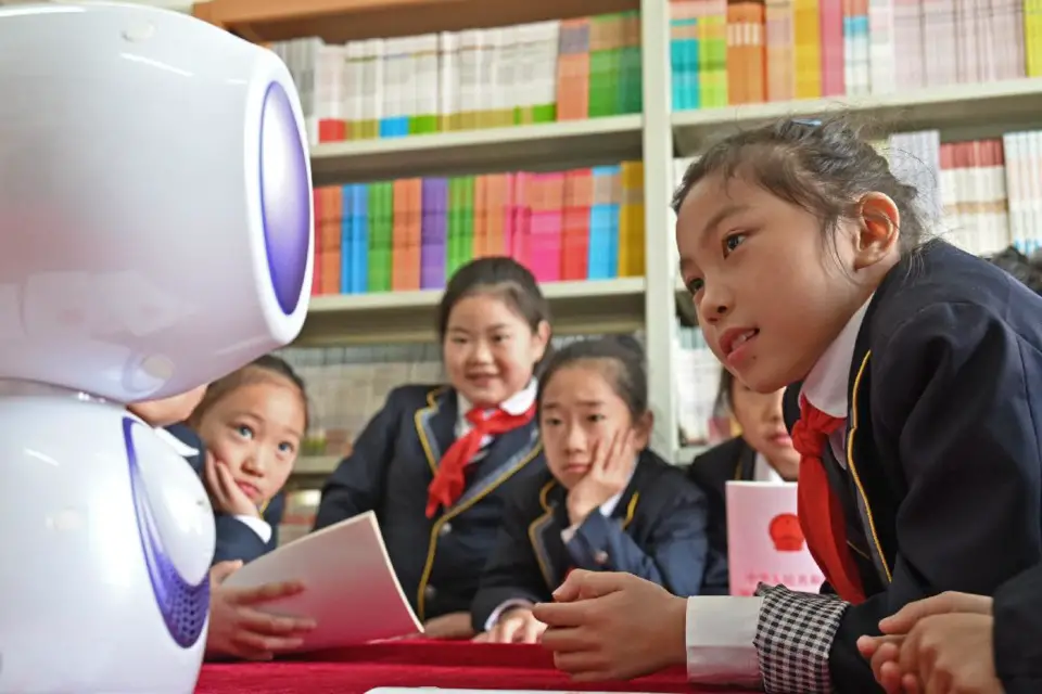 A robot helps popularize knowledge of the law among students in Yuanhui district, Luohe city, central China’s Henan province, Dec. 13, 2021. (Photo by You Yahui/People’s Daily Online)