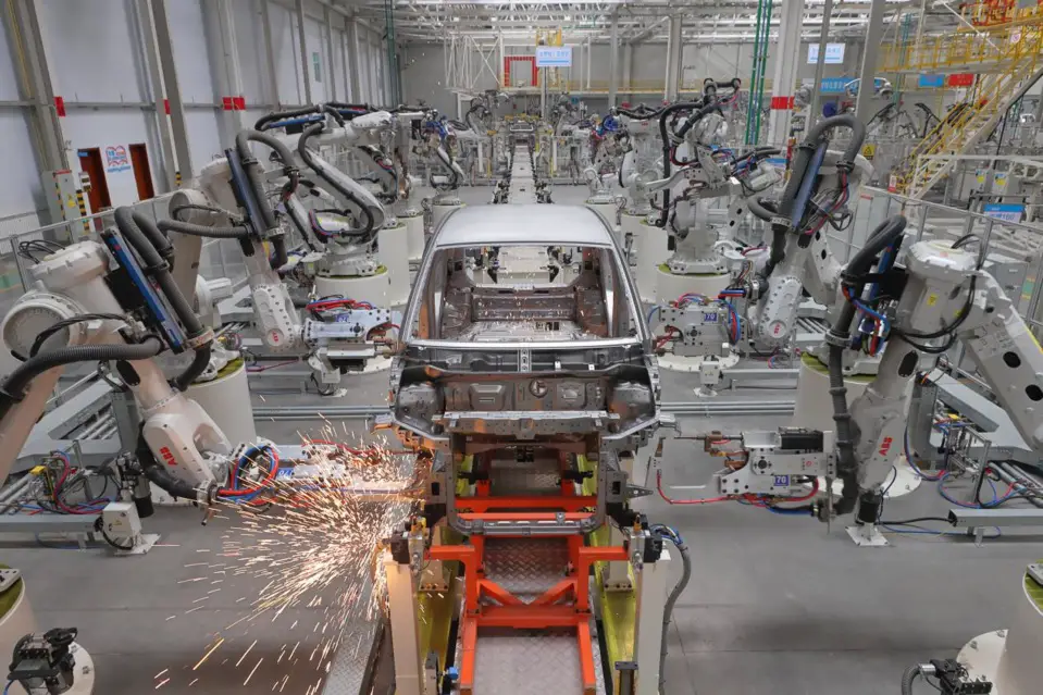 Photo taken on Jan. 14, 2022 shows smart mechanical arms welding the frame of a new-energy vehicle on a smart production line of a workshop of Dayun Automobile Co., Ltd. based in Yuncheng city, north China’s Shanxi province. (Photo by Yan Xin/People’s Daily Online)