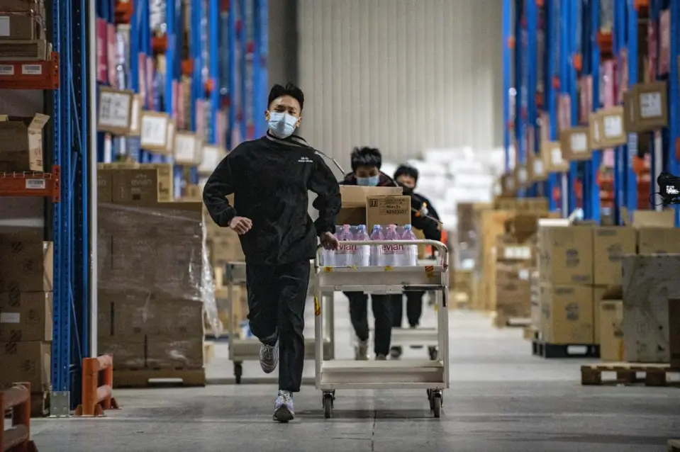 A man runs to collect parcels in a warehouse owned by Chinese e-commerce giant JD.com in Jinyi Comprehensive Bonded Zone, Jinhua, east China’s Zhejiang province, Dec. 12, 2021. (Photo by Hu Xiaofei/People’s Daily Online)