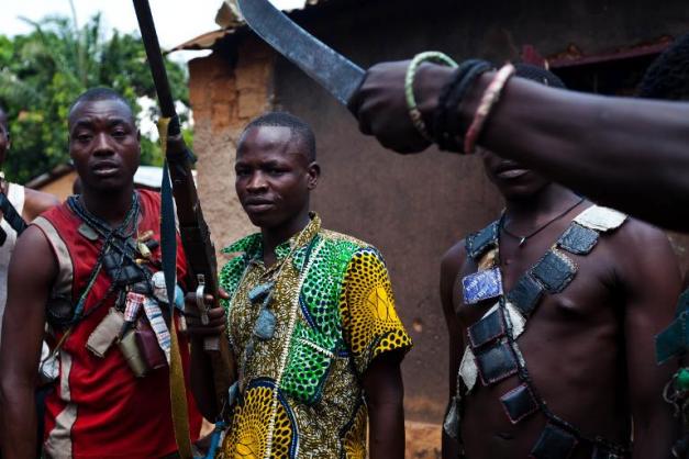 Des membres des milices anti-Balaka, opposés aux combattants Séléka, montrent leurs armes dans un village près de Bangui le 13 décembre 2013 ( AFP / Ivan Lieman)