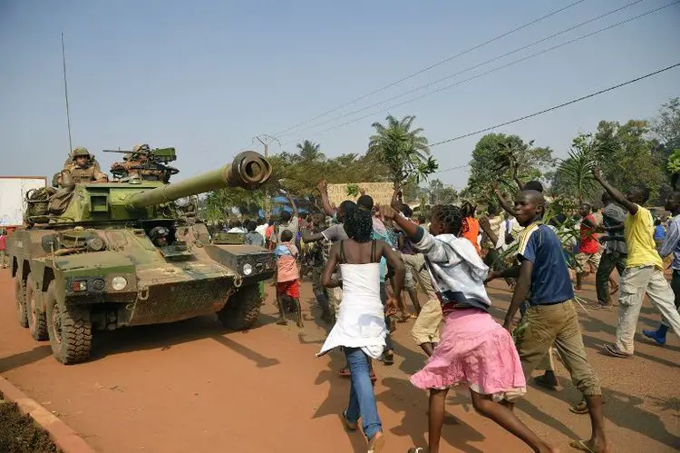 Des manifestants anti-Séléka, hostiles à Michel Djotodia, passent près d'un blindé français le 10 janvier à Bangui. (Photo Eric Feferberg. AFP)
