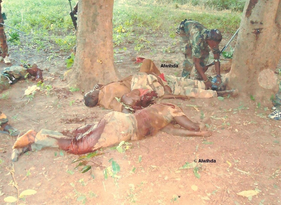 Un combattant enlève la chaussure d'un soldat des FACA tué au combat. © Alwihda Info