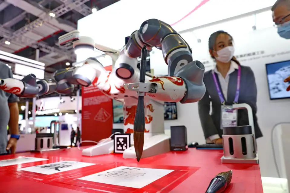 An artificially intelligent robot impresses visitors with its Chinese calligraphy skills at the fourth China International Import Expo held in the National Exhibition and Convention Center (Shanghai) in east China’s Shanghai, Nov. 6, 2021. (Photo by Xu Congjun/People’s Daily Online)