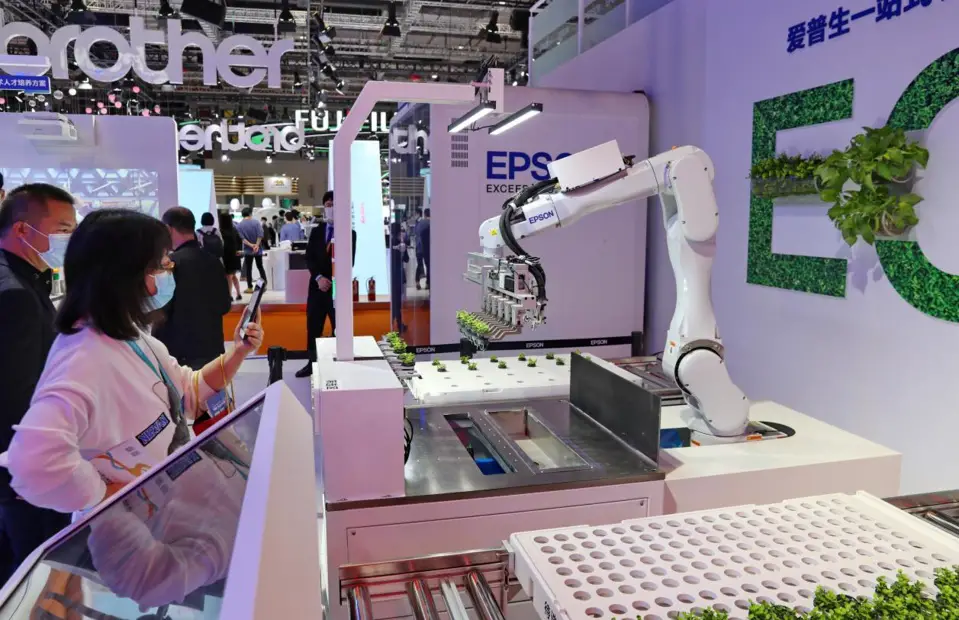 A 6-axis robot developed by Japanese electronics company Seiko Epson Corporation that can screen and grow seedlings attracts visitors at the fourth China International Import Expo held in the National Exhibition and Convention Center (Shanghai) in east China’s Shanghai, Nov. 6, 2021. (Photo by Xu Congjun/People’s Daily Online)