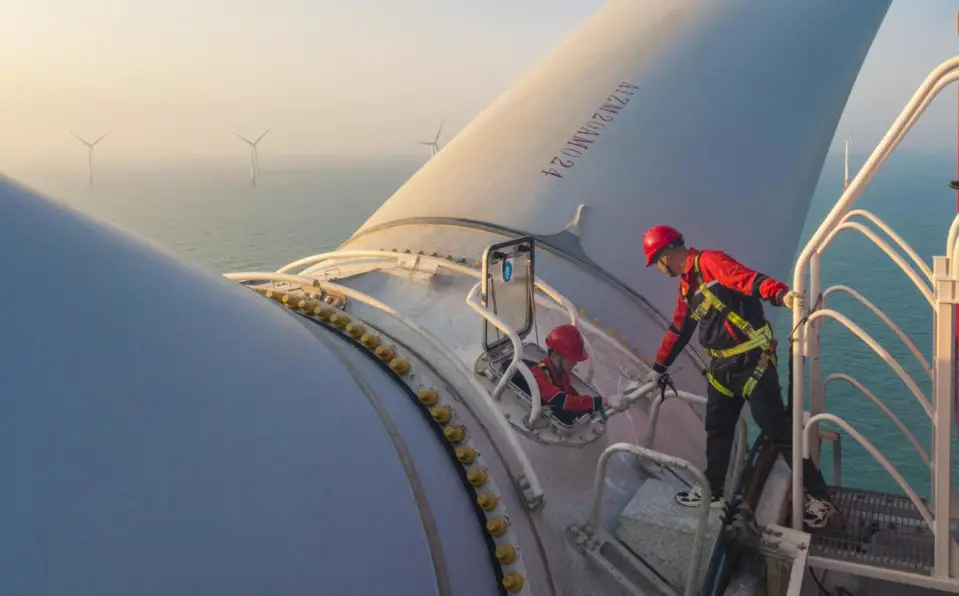 Technicians maintain a wind turbine at a wind farm in Zhuhai, south China's Guangdong province, April 12, 2021. (Photo by Qiu Xinsheng/People's Daily Online)
