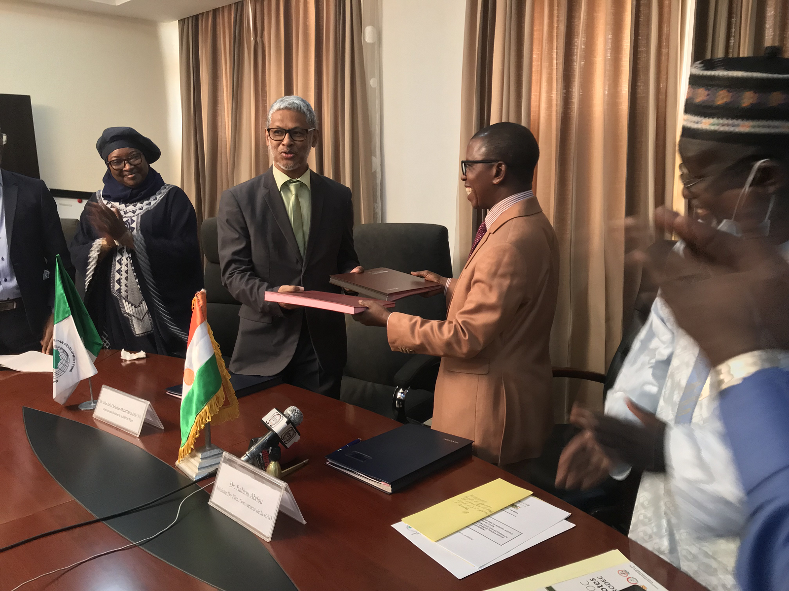 Échange de documents entre le responsable pays de la BAD et le ministre Nigérien du Plan après la signature des accords. © Afdb