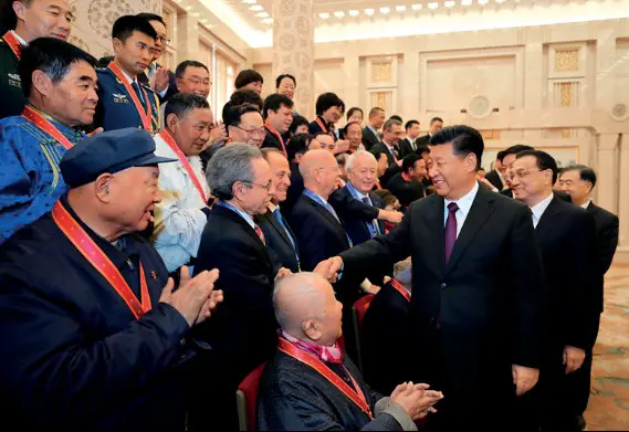 Chinese President Xi Jinping, also general secretary of the Communist Party of China (CPC) Central Committee and chairman of the Central Military Commission, shakes hands with Robert Lawrence Kuhn, chairman of the Kuhn Foundation, who was awarded a China reform friendship medal, after the conclusion of a grand gathering held at the Great Hall of the People in Beijing to celebrate the 40th anniversary of China’s reform and opening-up on Dec. 18, 2018.
