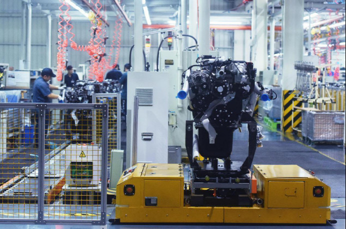 An AI-powered robot carries a heavy truck engine at a factory of SINOTRUK Hangzhou Engine Co., Ltd. located in a robot manufacturing base in Xiaoshan Economic and Technological Development Zone, Hangzhou city, east China’s Zhejiang province, Oct. 18, 2021. (Photo by Long Wei/People’s Daily Online)