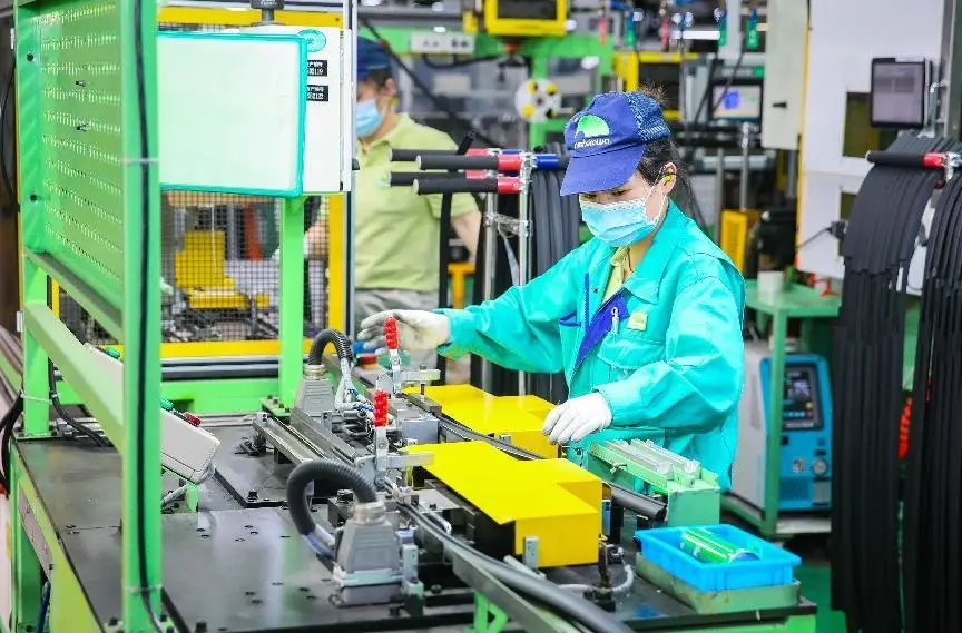 Photo taken on May 15, 2022, shows busy workers in the manufacturing shop of a company based in Songjiang district, east China’s Shanghai. (Photo by Cai Bin/People’s Daily Online)