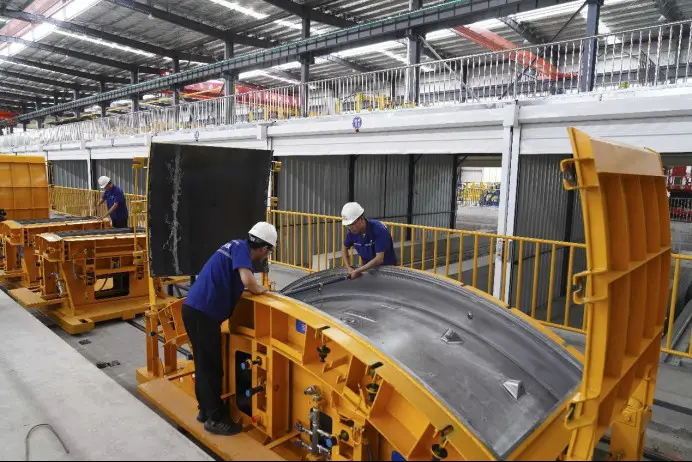 Technicians examine the precision of subway tunnel segment mold at a green intelligent building industrial base of China Railway Construction Corporation Limited (CRCC) in Beibei district, southwest China’s Chongqing municipality, April 25, 2022. The industrial base uses modular prefabricated components and assembles them at construction sites, shifting tasks that were formerly performed on construction sites to factories. (Photo by Qin Tingfu/People’s Daily Online)