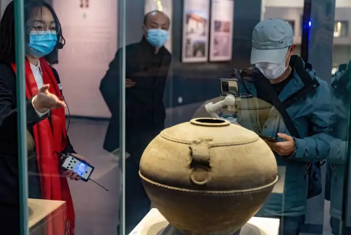 A staff member who runs the account of the museum of Feidong county, Hefei city, east China’s Anhui province, on Chinese short video sharing platform Douyin, together with a docent, shows the cultural relics housed in the museum via livestreaming, Feb. 16, 2021. (Photo by Ruan Xuefeng/People’s Daily Online)