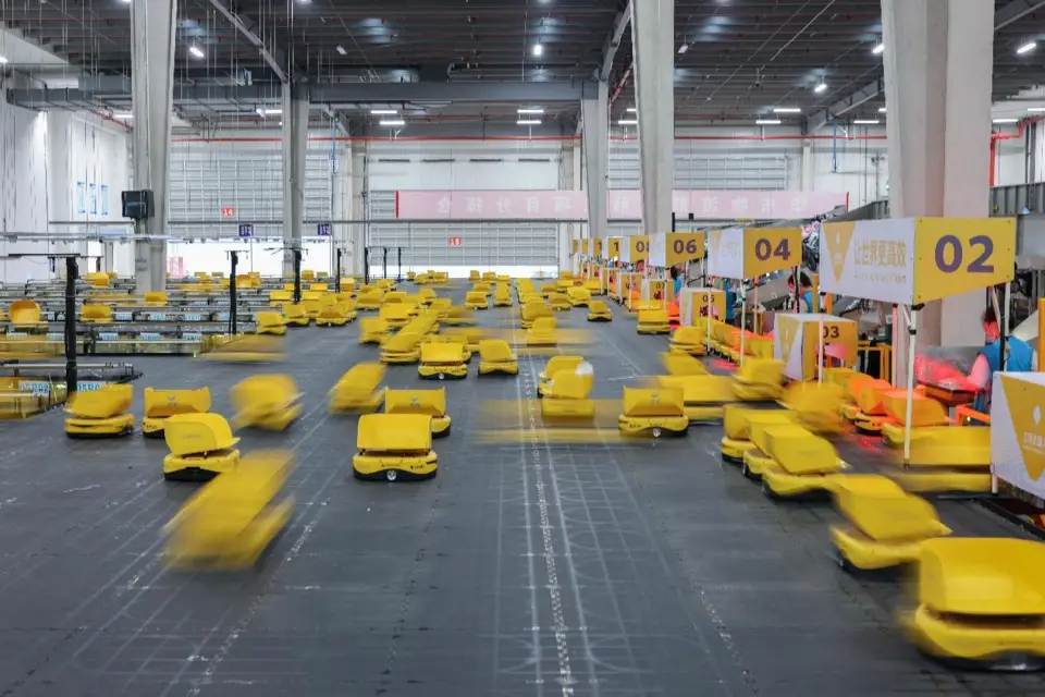 Robots are sorting commodities at a logistics center of a garment company in Deqing county, Huzhou, east China's Zhejiang province, June 16, 2022. (Photo by Cai Jun/People's Daily Online)