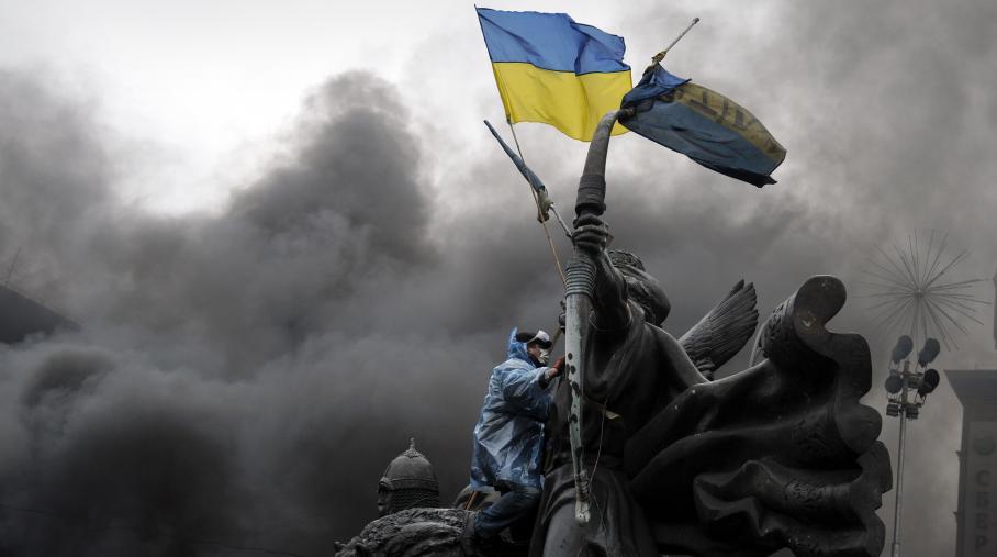 Un manifestant à Kiev brandit un drapeau ukrainien, le 20 février 2014. (LOUISA GOULIAMAKI / AFP)