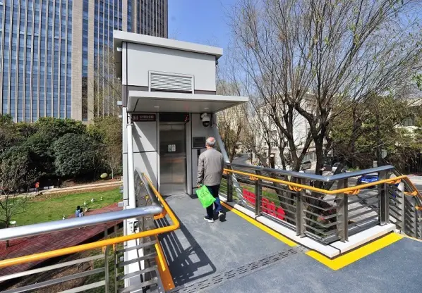 A barrier-free elevator is put into use on a pedestrian overpass in Shanghai, March 2022. Photo shows a citizen waiting for the elevator.(Photo by Yang Jianzheng/People's Daily Online)