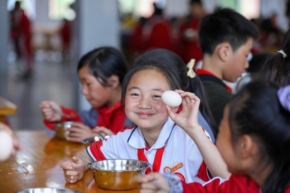 Students are having meals at a primary school at a relocation site for poverty alleviation in Kaiyang county, Guiyang, southwest China's Guizhou province, May 2022. The county offers free meals for students. Each meal includes three dishes and a bowl of soup, as well as a fruit or a cup of milk. (Photo by Yuan Fuhong/People's Daily Online)