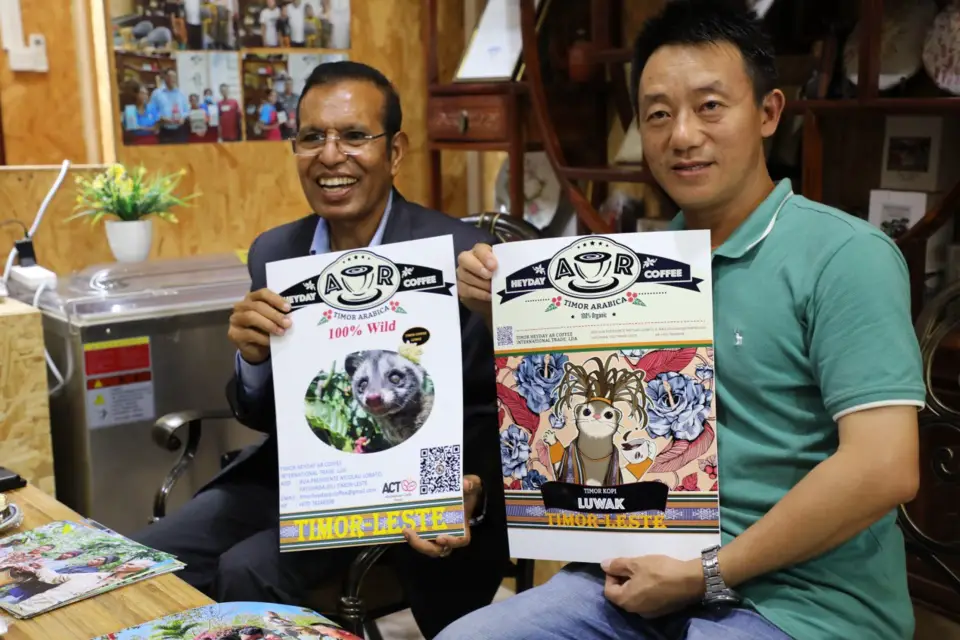 Taur Matan Ruak, Timor-Leste's Prime Minister, and Mr.Chen Lisong the owner of Heyday AR Coffee in Timor-Leste, hold posters of the coffee shop, Oct. 11, 2022. (Photo by Sun Guangyong/People's Daily)