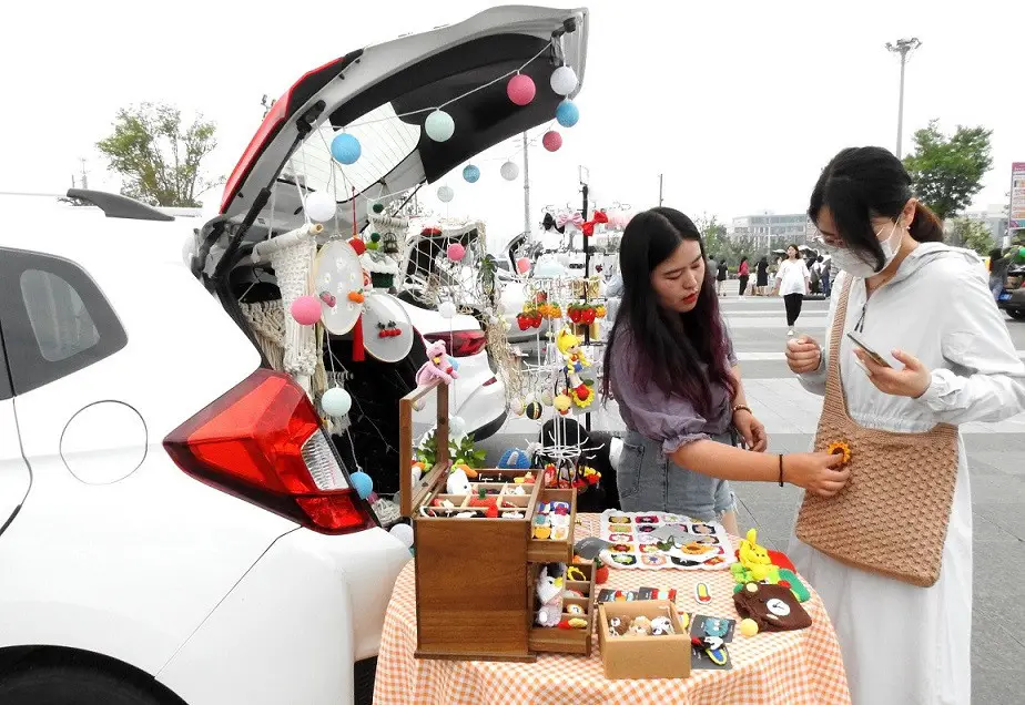 A citizen buys handicrafts from a trunk market at Wanda Plaza in Lianyungang city, east China's Jiangsu province, June 2020. (Photo by Geng Yuhe/People's Daily Online)
