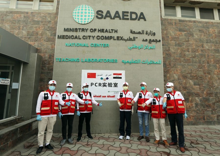 A Chinese team of health experts sent to provide assistance to contain the COVID-19 outbreak in Iraq pose for a group photo outside the new PCR laboratory in Baghdad, Iraq, March 25, 2020. (Xinhua/Khalil Dawood)