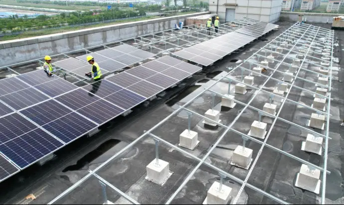 Workers install distributed photovoltaic power modules on the roof of a factory at a China-German enterprises cooperation park in the Lianyungang Economic and Technological Development Zone in Lianyungang, east China's Jiangsu province, July 5, 2022. (Photo by Geng Yuhe/People's Daily Online)