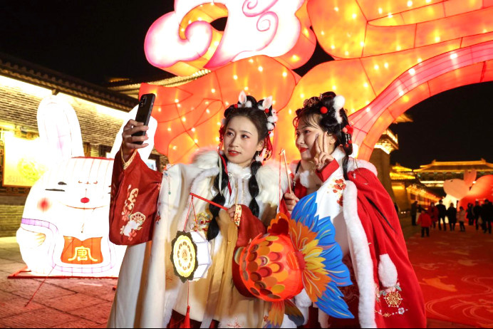 Tourists pose for pictures at a miaohui, literally a temple gathering or temple fair, in Xiangyang, central China's Hubei province, Jan. 18, 2023. (Photo by Yang Dong/People's Daily Online)