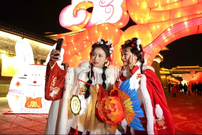 Tourists pose for pictures at a miaohui, literally a temple gathering or temple fair, in Xiangyang, central China's Hubei province, Jan. 18, 2023. (Photo by Yang Dong/People's Daily Online)