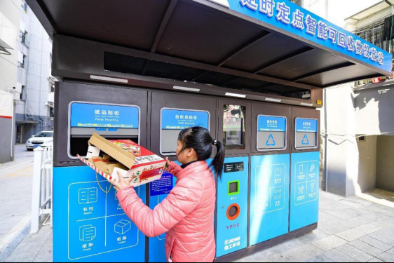 A citizen puts garbage into a smart recycling machine in Ganzhou, east China's Jiangxi province. (Photo by Hu Jiangtao/People's Daily Online)