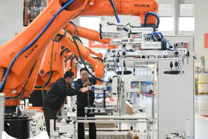 Workers debug robotic arms in a workshop of an intelligent equipment enterprise in Ningde, east China's Fujian province, March 8, 2023. (Photo by Wang Wangwang/People's Daily)