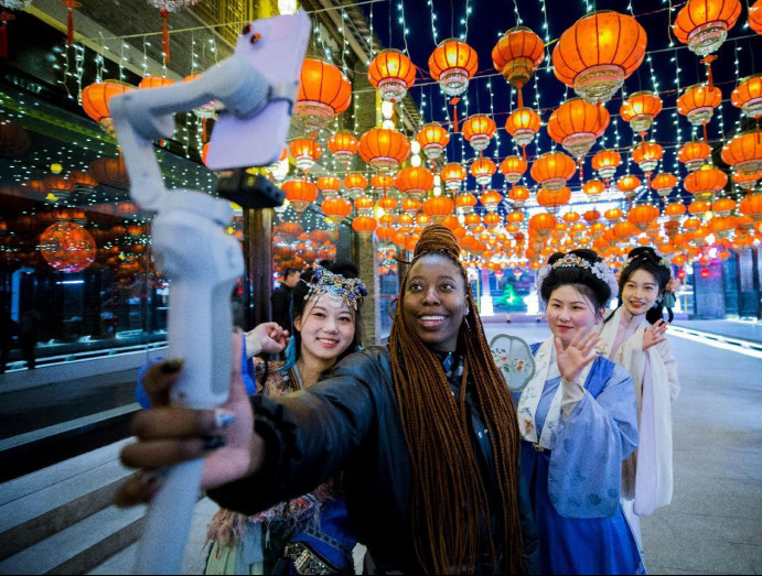 A foreign tourist takes photos with enthusiasts of Hanfu, the traditional clothing of the Han ethnic group in China, at an ancient town in Huai'an city, east China's Jiangsu province, March 4, 2023. (Photo by Zhu Tianyu/People's Daily Online)