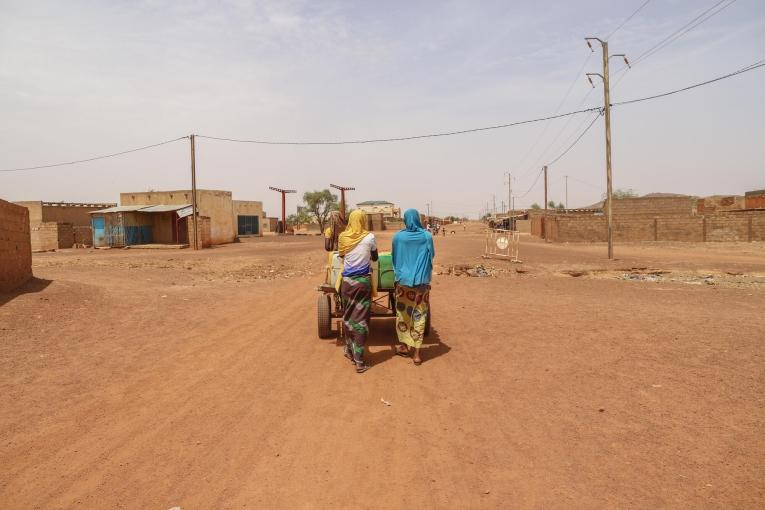 Centre-ville de Djibo - deux femmes poussant une charrette d'eau. © MSF/Nisma Leboul