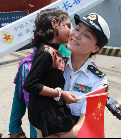 A fleet of Chinese naval vessels paid a friendly visit to Bangladesh in 2017. Photo shows Bangladeshi girl Alifa Chin and a Chinese military doctor in Chittagong, Bangladesh. (Photo by Shi Kuiji)