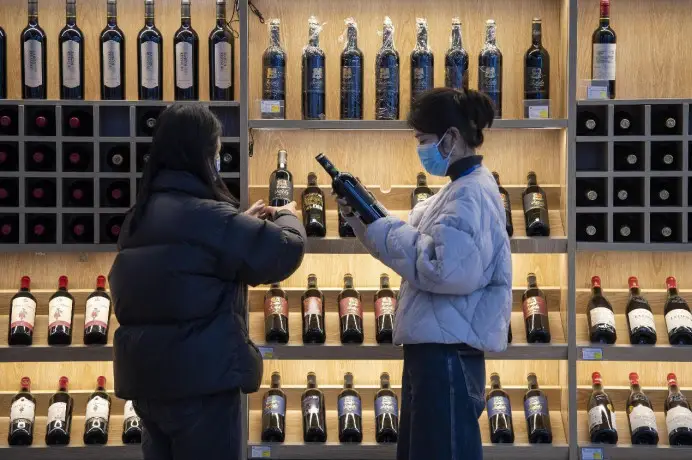 Consumers buy imported wine at a shopping center in Jinyi Comprehensive Free Trade Zone in Jinhua, east China's Zhejiang province. (Photo by Hu Xiaofei/People's Daily Online)