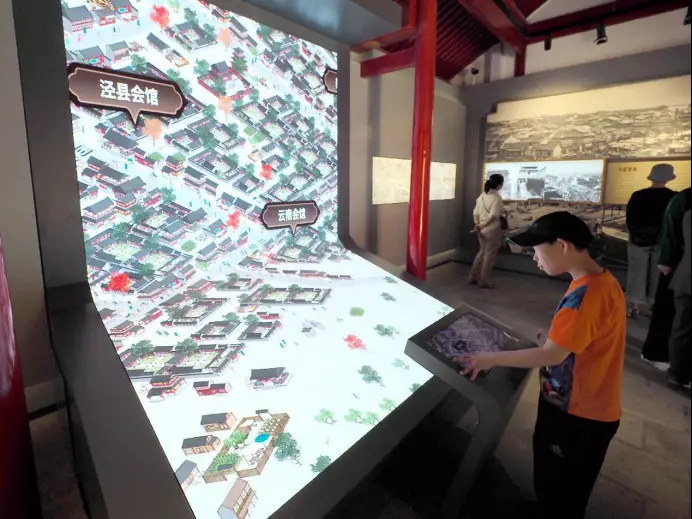 A visitor uses a digital device at the Beijing Xuannan Cultural Museum. (Photo by Du Jianpo/People's Daily Online)