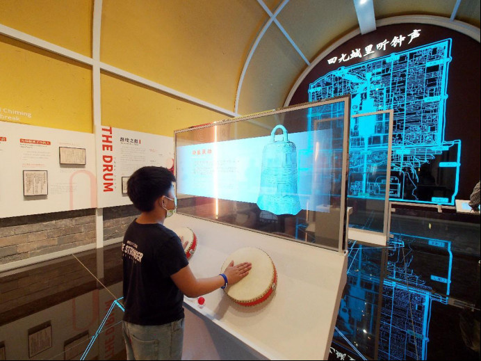 A child experiences virtual drumming at an exhibition held at the Drum Tower in Beijing. (Photo by Du Jianpo/People's Daily Online)