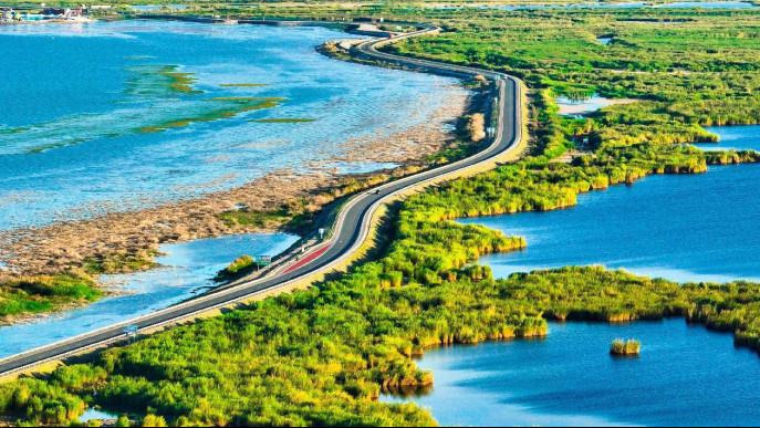 Photo shows a riverbank road near the Bosten Lake in Bayingolin Mongolian autonomous prefecture, northwest China's Xinjiang Uygur autonomous region. (Photo by Nian Lei/People's Daily Online)
