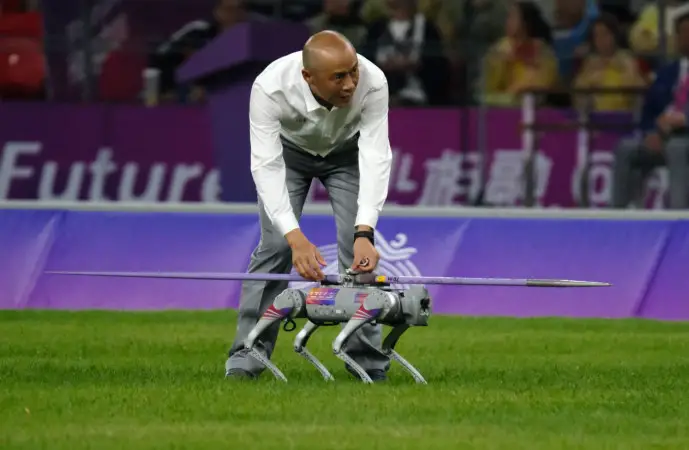 A "robot dog" transports a javelin during a javelin competition of the Hangzhou Asian Games, Oct. 3, 2023. (Photo by Wu Huang/People's Daily Online)