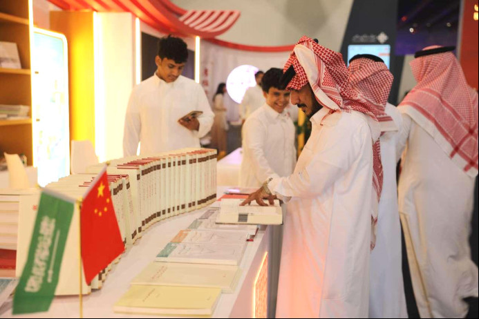 Saudi Arabian readers browse at the exhibition booth for Chinese books at the Riyadh International Book Fair 2023. (Photo by Zhang Zhiwen/People's Daily)