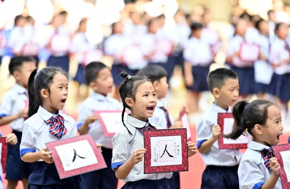 First graders at an elementary school in Liuzhou, south China's Guangxi Zhuang autonomous region, recite Chinese classics under the guidance of their teachers. (Photo by Li Hanchi/People's Daily Online)