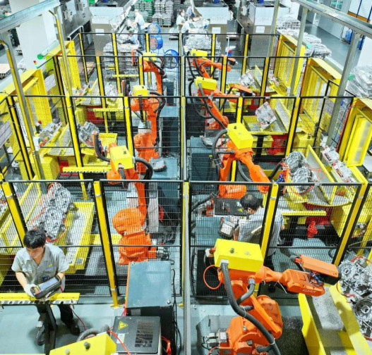 Technicians control robotic arms to produce new energy vehicle parts in a smart factory in Ganzhou, east China's Jiangxi province. (Photo by Zhu Haipeng/People's Daily Online)