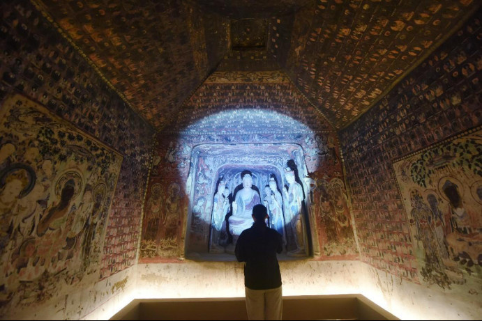 A tourist visits a 3D-printed recreation of Cave 57 of the Mogao Grottoes at the Zhejiang Art Museum in Hangzhou, east China's Zhejiang province. (Photo by Long Wei/People's Daily Online)