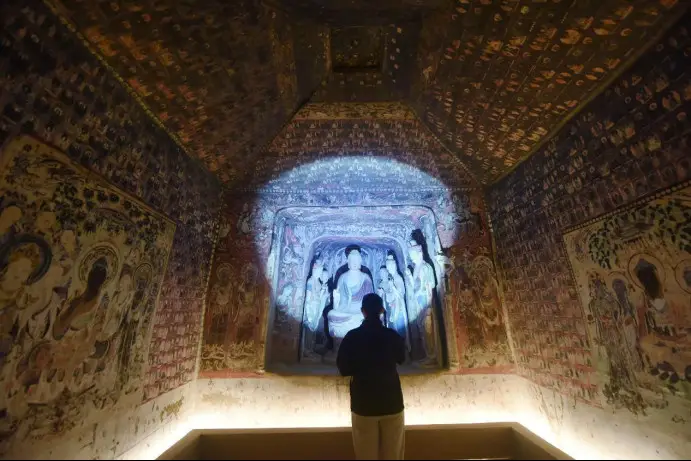A tourist visits a 3D-printed recreation of Cave 57 of the Mogao Grottoes at the Zhejiang Art Museum in Hangzhou, east China's Zhejiang province. (Photo by Long Wei/People's Daily Online)