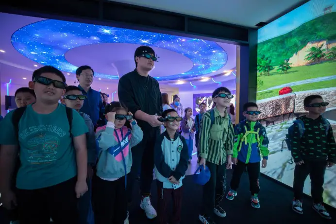 Children learn to paint with artificial intelligent wearing virtual reality headsets at the Hefei University of Economics in east China's Anhui province. (Photo by Luo Xianyang/People's Daily Online)