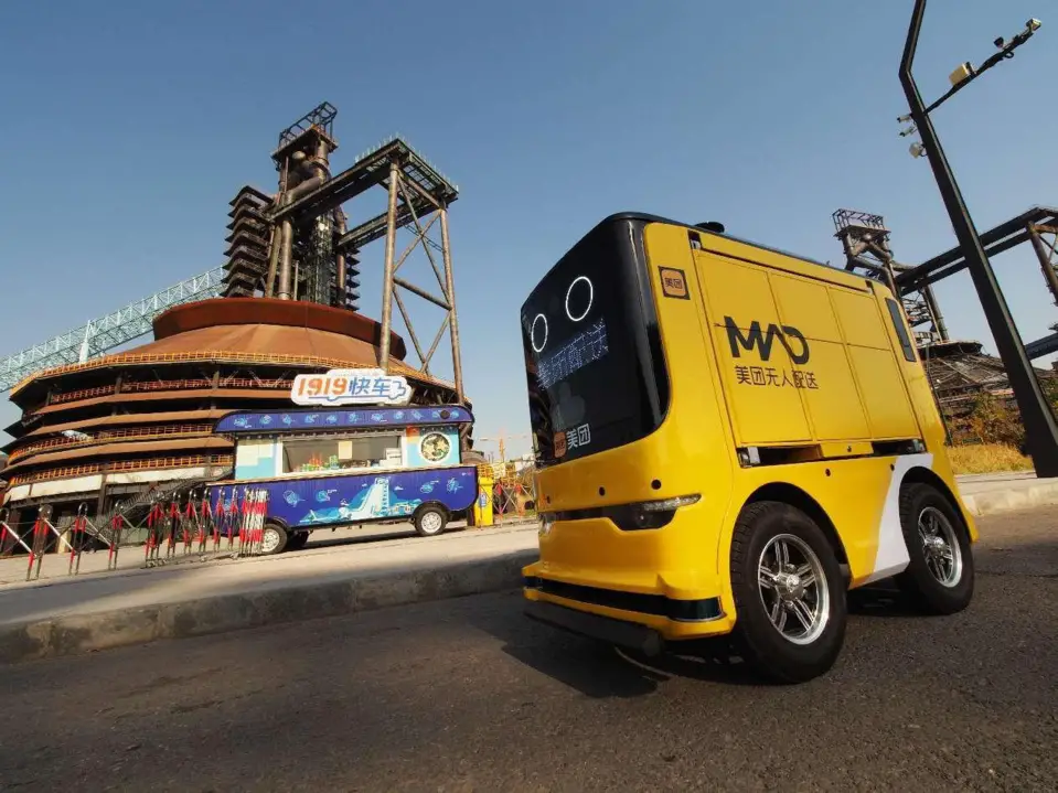 An autonomous delivery vehicle of Meituan runs in the Shougang Park in Beijing. (Photo by Du Jianpo/People's Daily Online)