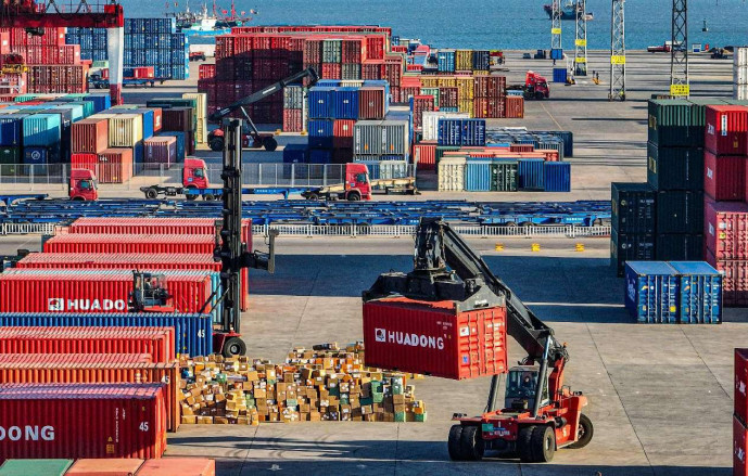 Containers are handled on a container yard of a port in Rongcheng, east China's Shandong province. (Photo by Li Xinjun/People's Daily Online)