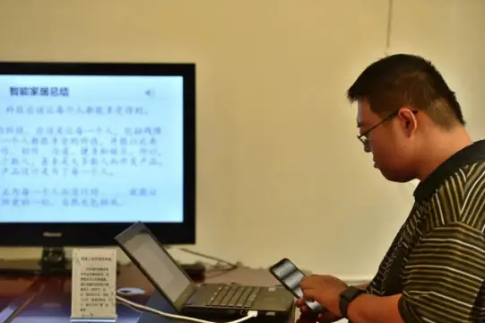 Wang makes courseware with a laptop. (Photo from the media center of Nankai district, Tianjin municipality)