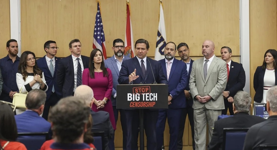 Le gouverneur de Floride, Ron De Santis, au centre, prononce un discours à l'intérieur du bâtiment MARC de la Florida International University à Miami, le 24 mai 2021. Photo : Carl Juste/Miami Herald/AP