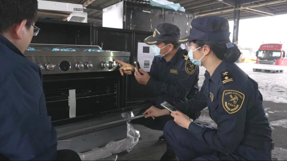 Officials of Guangzhou customs inspect the initial exhibits arriving for the 135th session of the Canton Fair on March 17. (Photo by Han Jianquan)