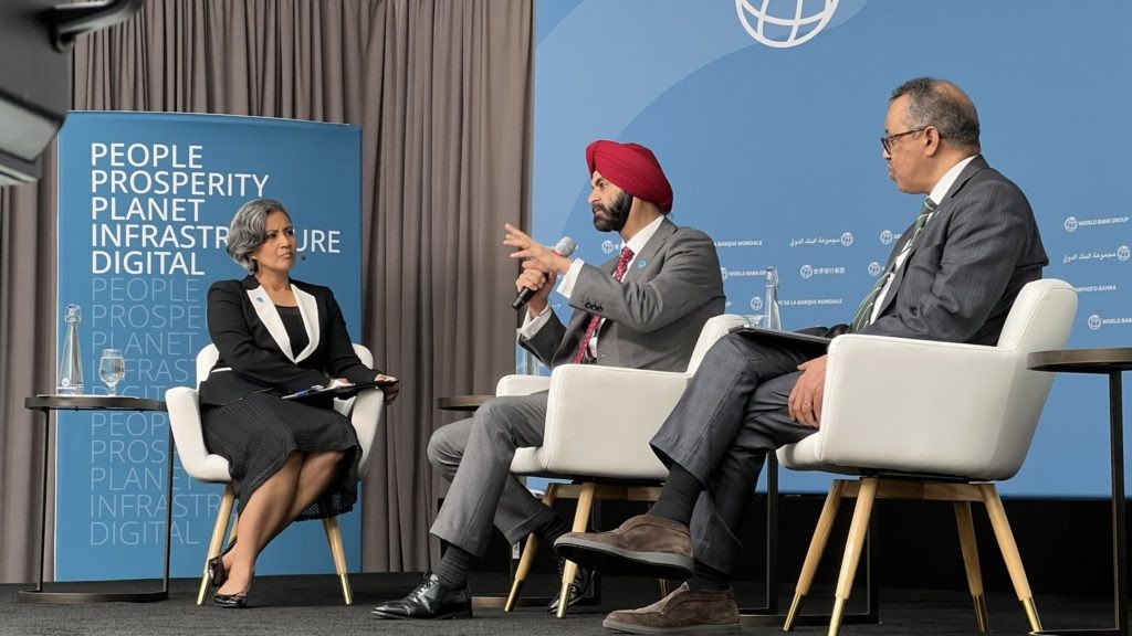 Le président de la Banque mondiale, Ajay Banga (au centre), prend la parole lors d'un événement. Il est flanqué de Shakuntala Santhiran et du Dr Tedros de l’OMS. Photo : healthpolicy-watch.news