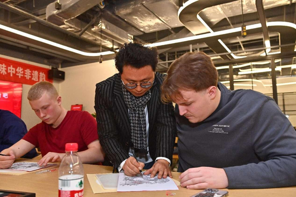 Young Germans experience paper knife cutting, an item of China's intangible cultural heritage, at Changzhou Library, east China's Jiangsu province. (Photo by Hu Ping/People's Daily Online)