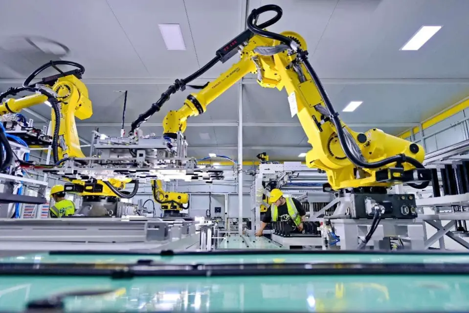 Intelligent robotic arms and automated production equipment are tested in a workshop of a power battery enterprise in Ganzhou, east China's Jiangxi province. (Photo by Zhu Haipeng/People's Daily Online)